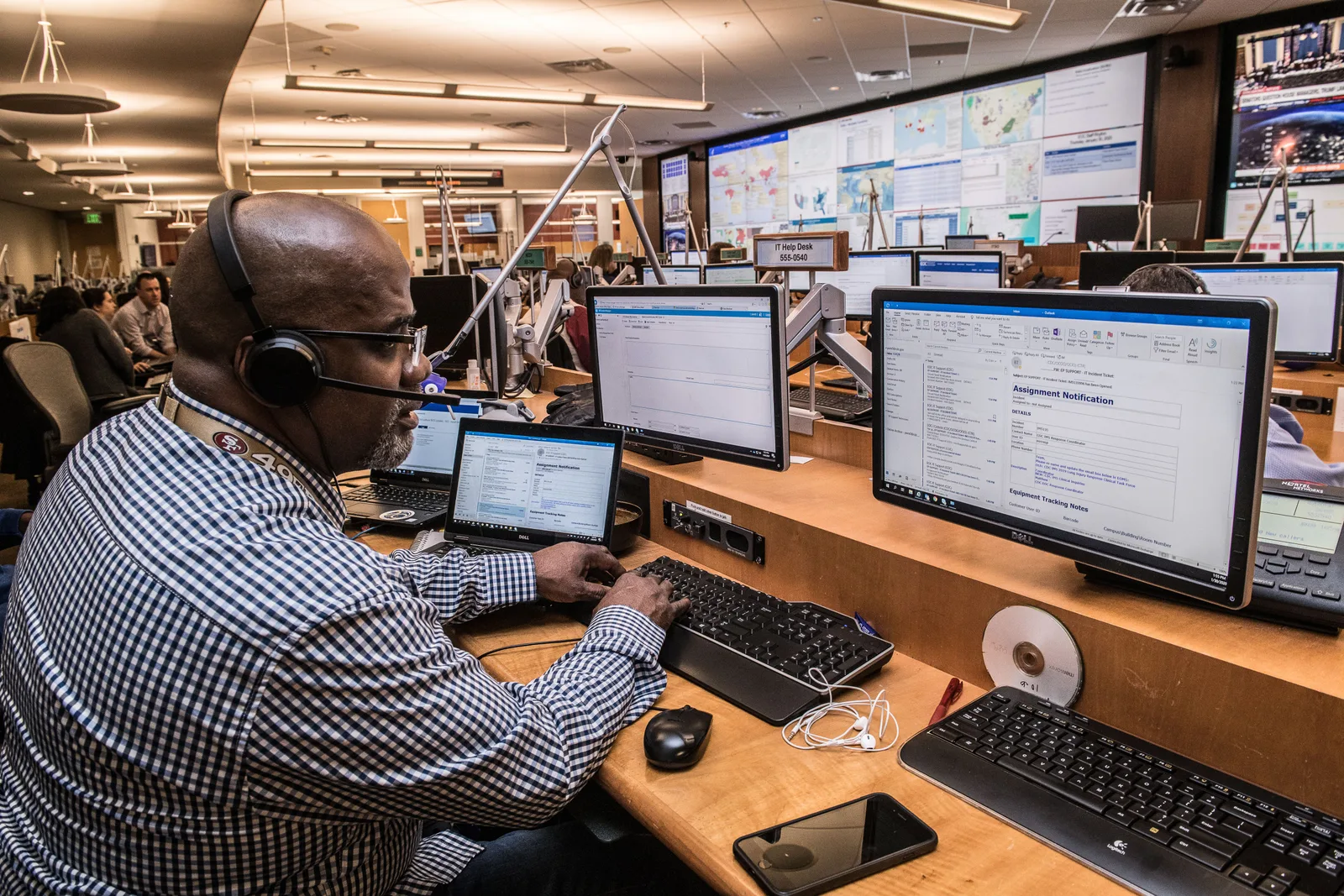 Focused man in office working on computers, engaged in technical research and communication. License fundamentals: finding business requirements